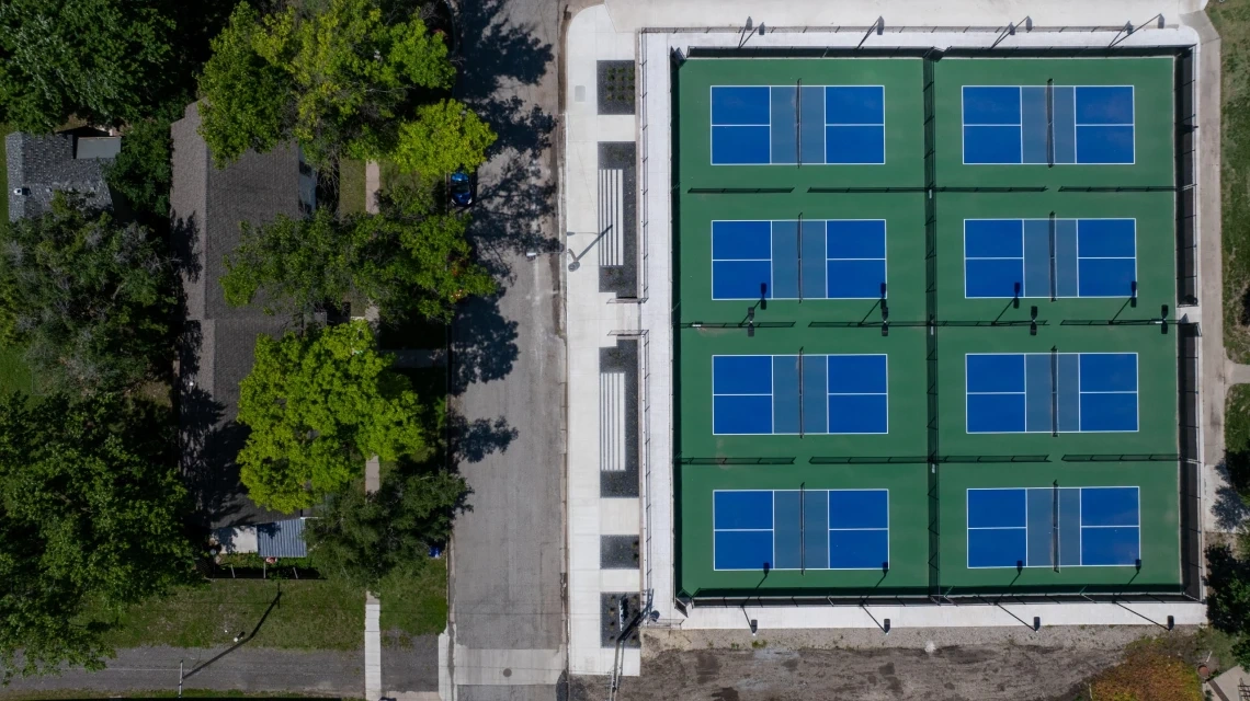 The eight McPherson pickleball courts from directly above, with the new entry walk, planting beds and seat walls along their west side.