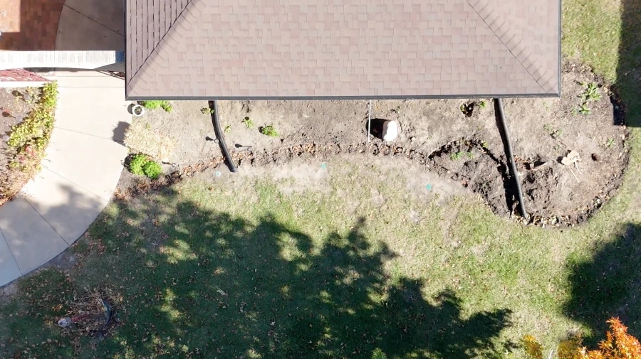 The same front bed from above, finished: mulch, young shrubs and grasses in place and new sod laid to the curve.