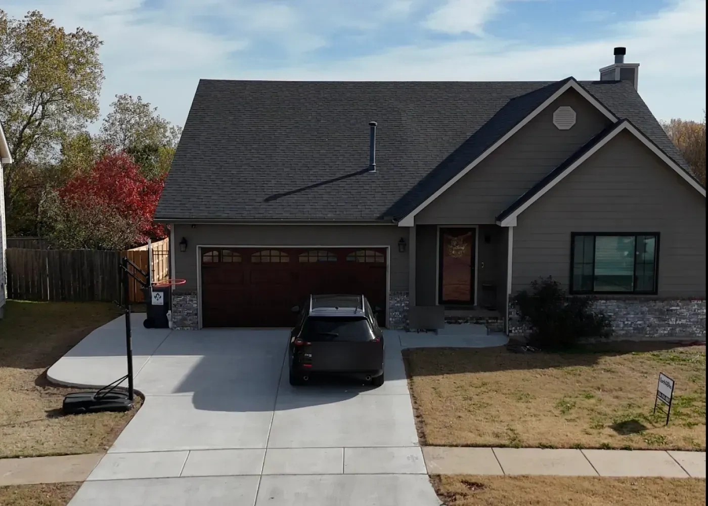 The finished Debroata frontage, with a new concrete drive and approach poured across the full width of the house and the lawn edge cut in beside it.