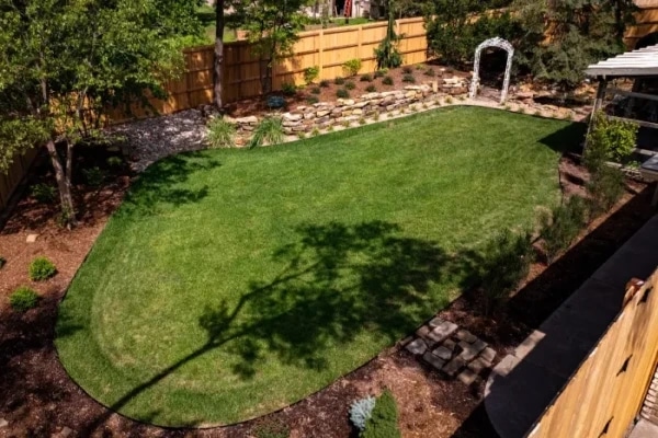 The Grainger back lawn from above, the arbour and stone wall at the far end and the cedar fence around it.